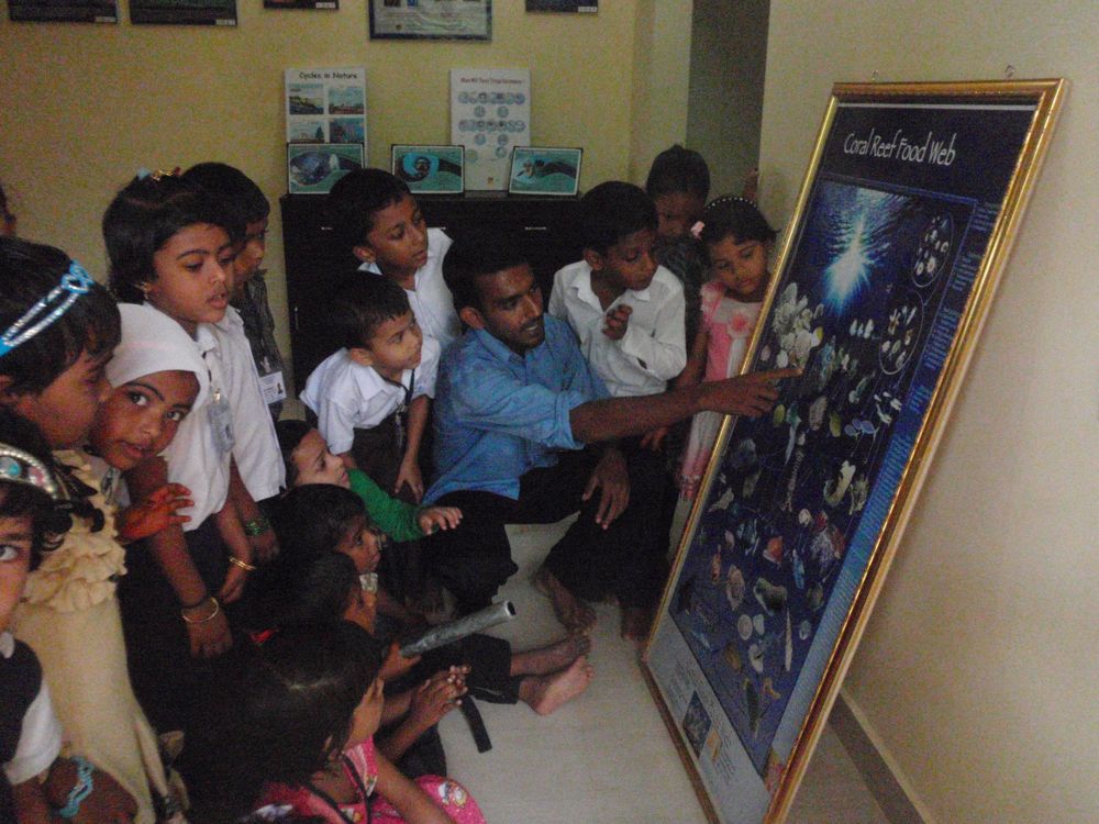 Schoolchildren gather around a teacher in India