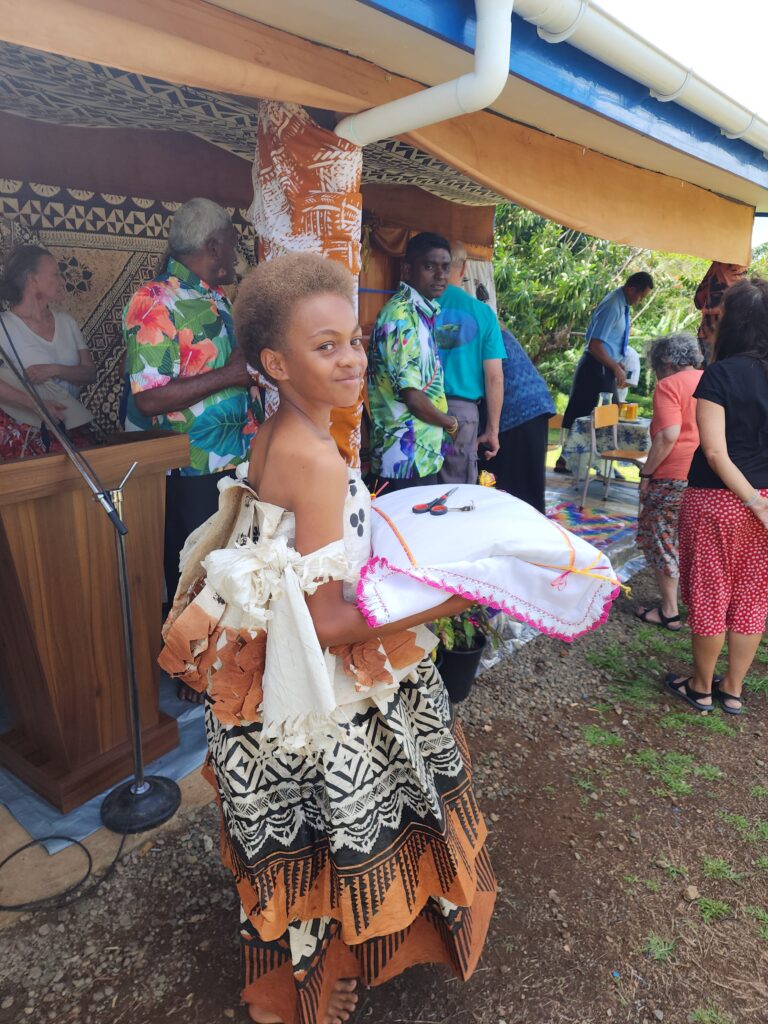 Local girl presents scissors for the ribbon-cutting ceremony