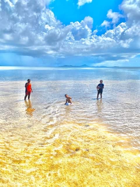 People play in shallow water at Kuop Atoll, Chuuk, Micronesia