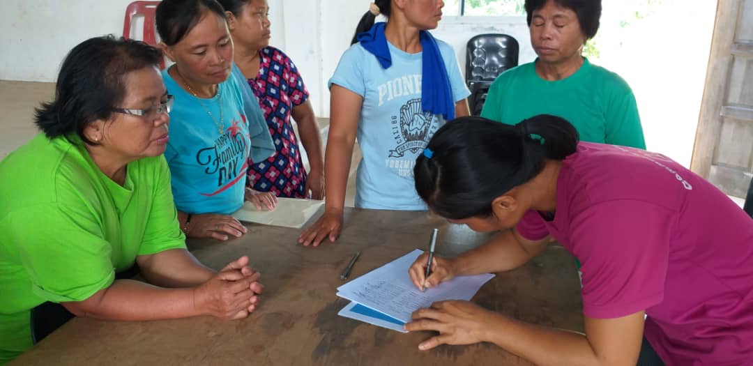 Tampasak community members, in Sabah, Malaysia, sign the forest protection agreement with Seacology