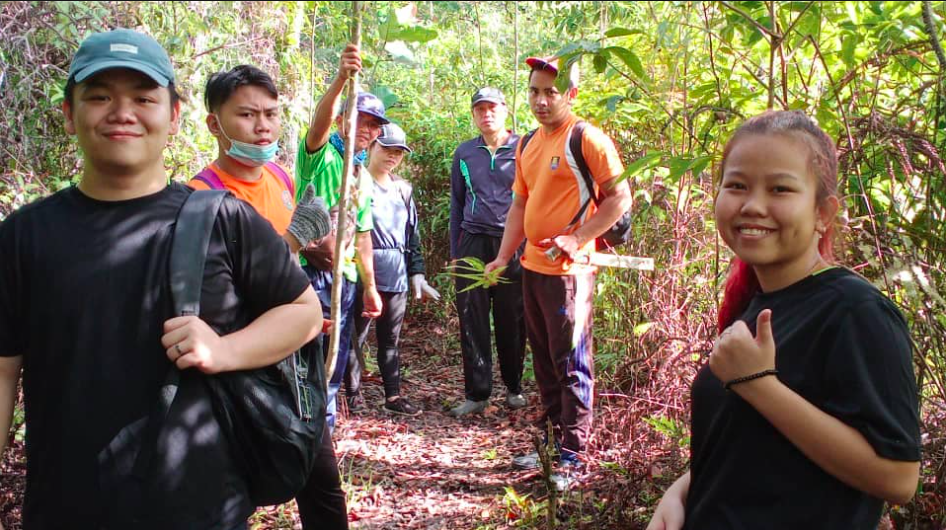 Young Malaysians stand in a forest