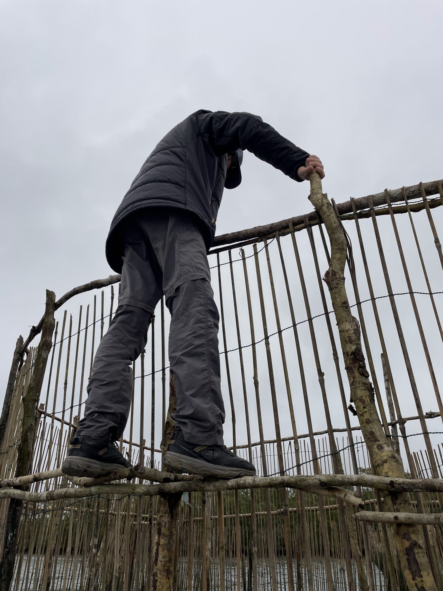 A man stands on top of a wooden structure