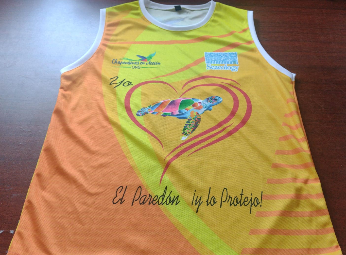 An orange and yellow tank top with a design of a sea turtle