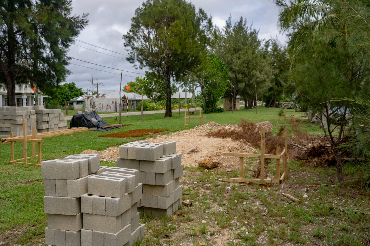 A pile of bricks sit next to a cleared construction site