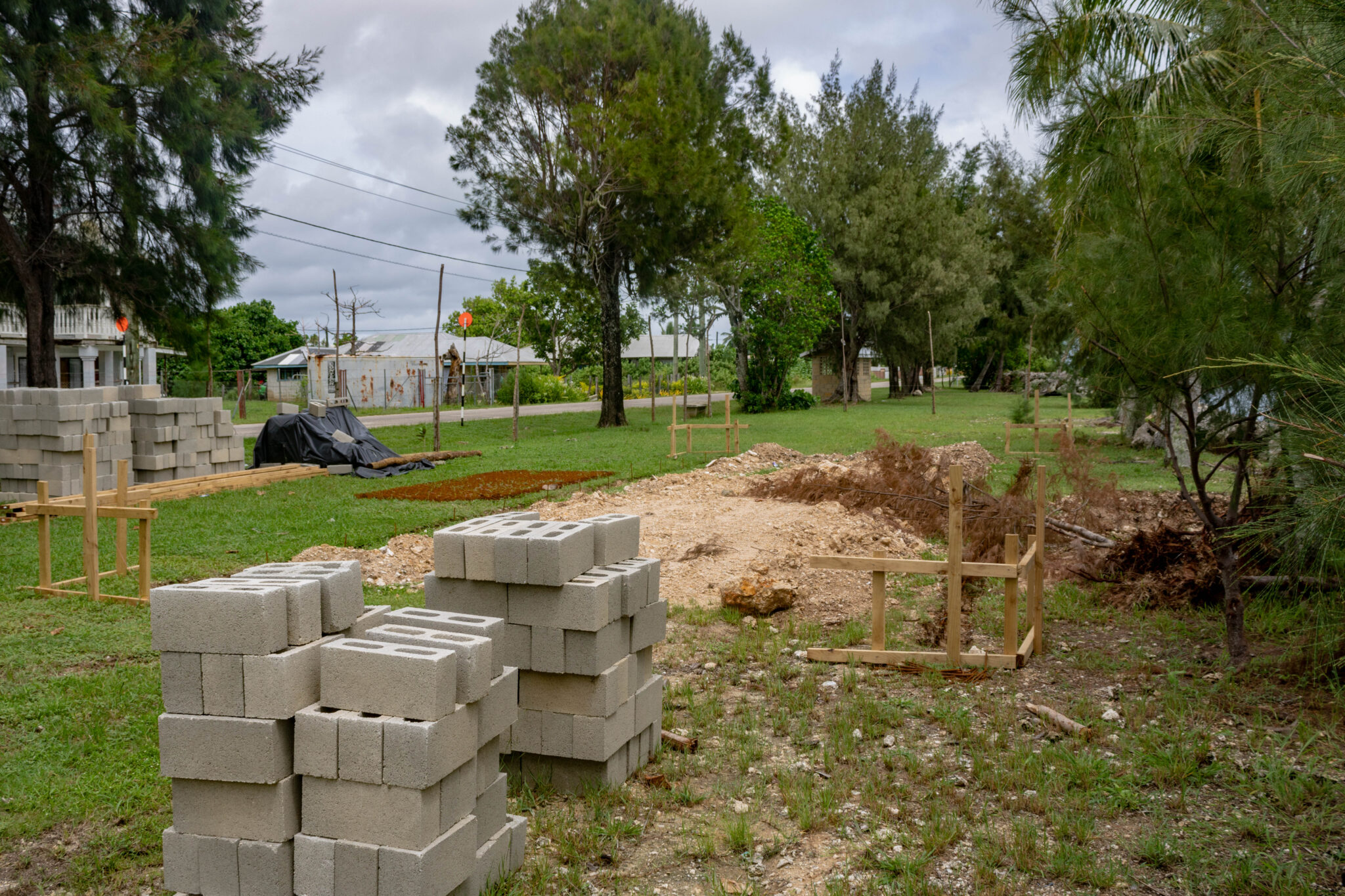 A pile of bricks sit next to a cleared construction site
