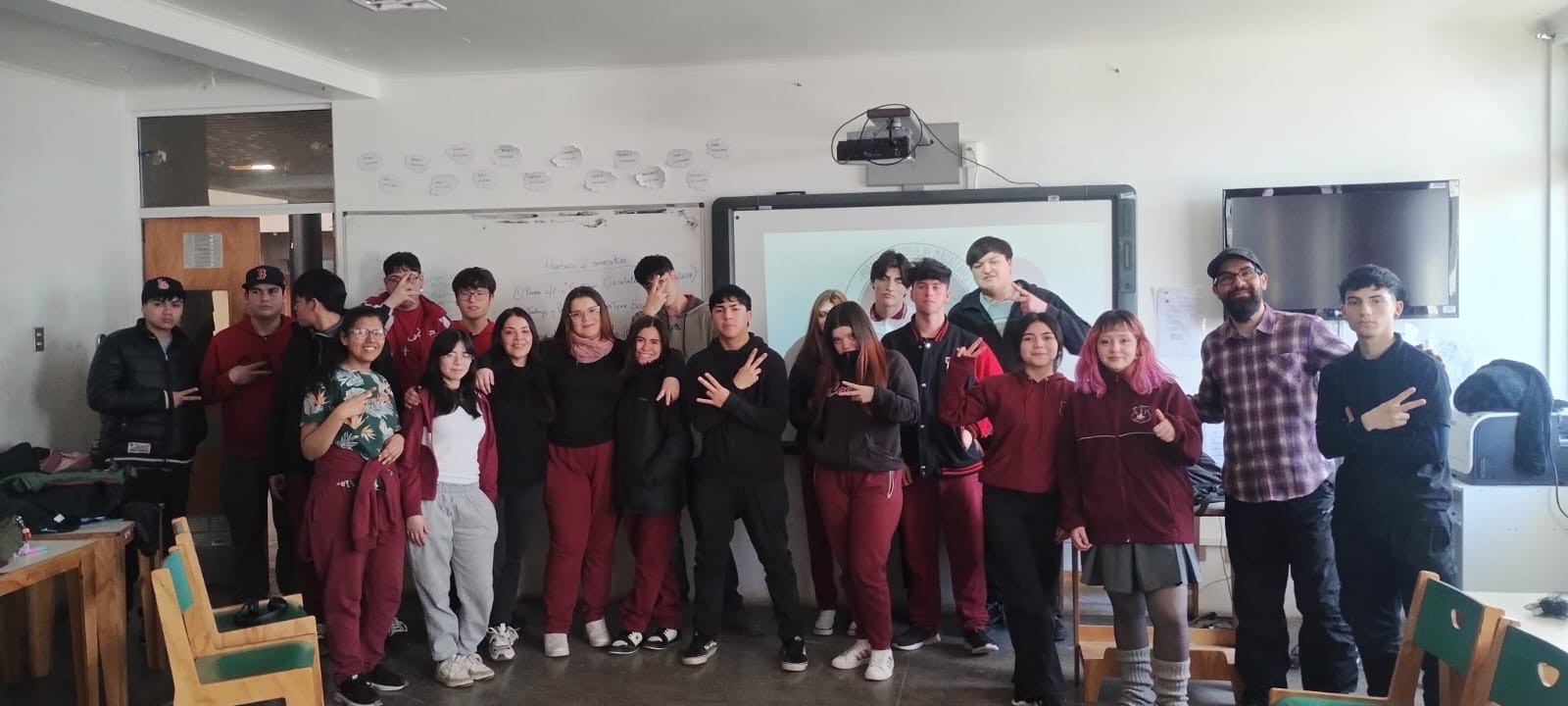 A group of people pose together in a classroom