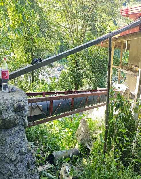 Pipe suspended in metal truss in forest