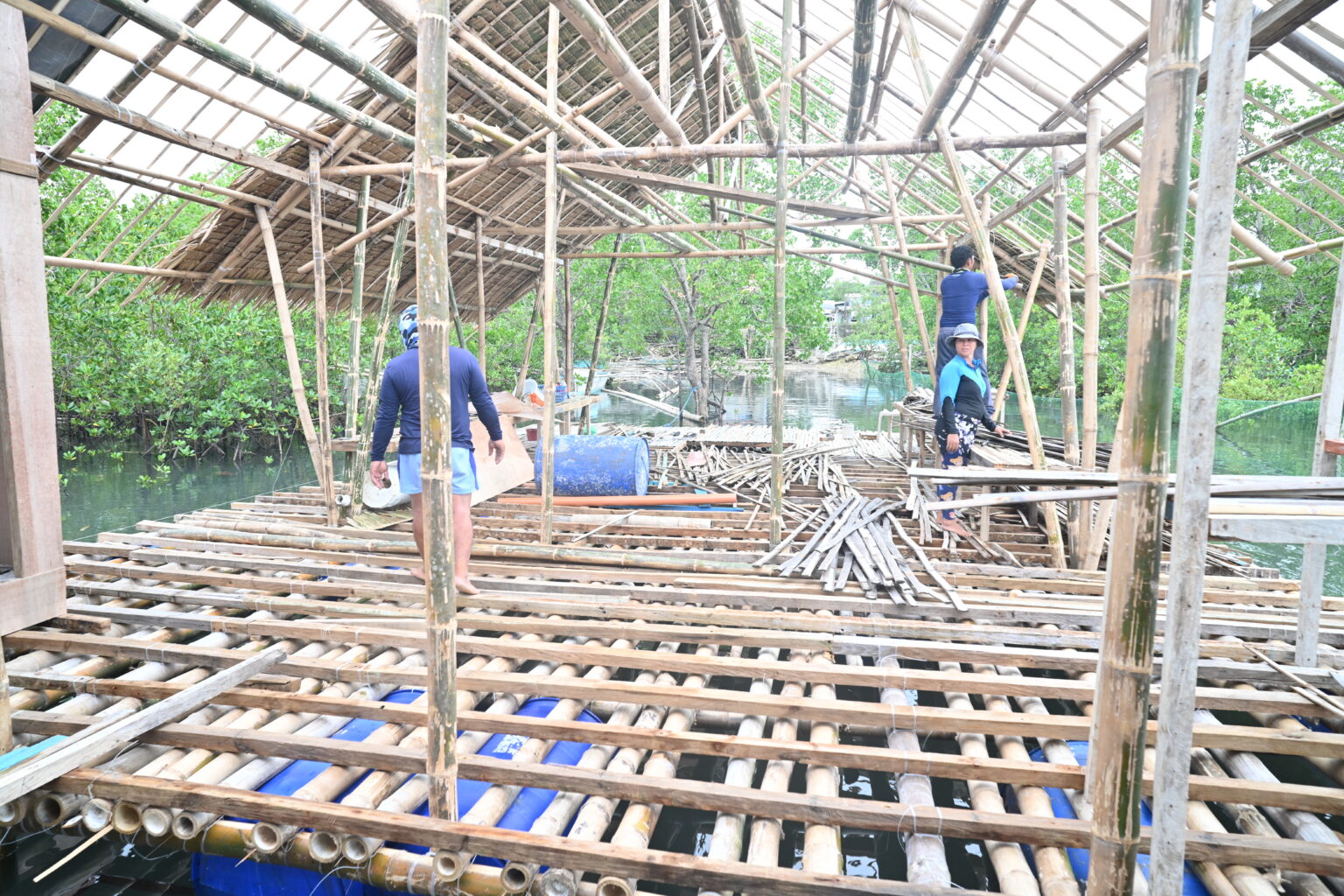 workers construct floor of partially rebuilt cabin