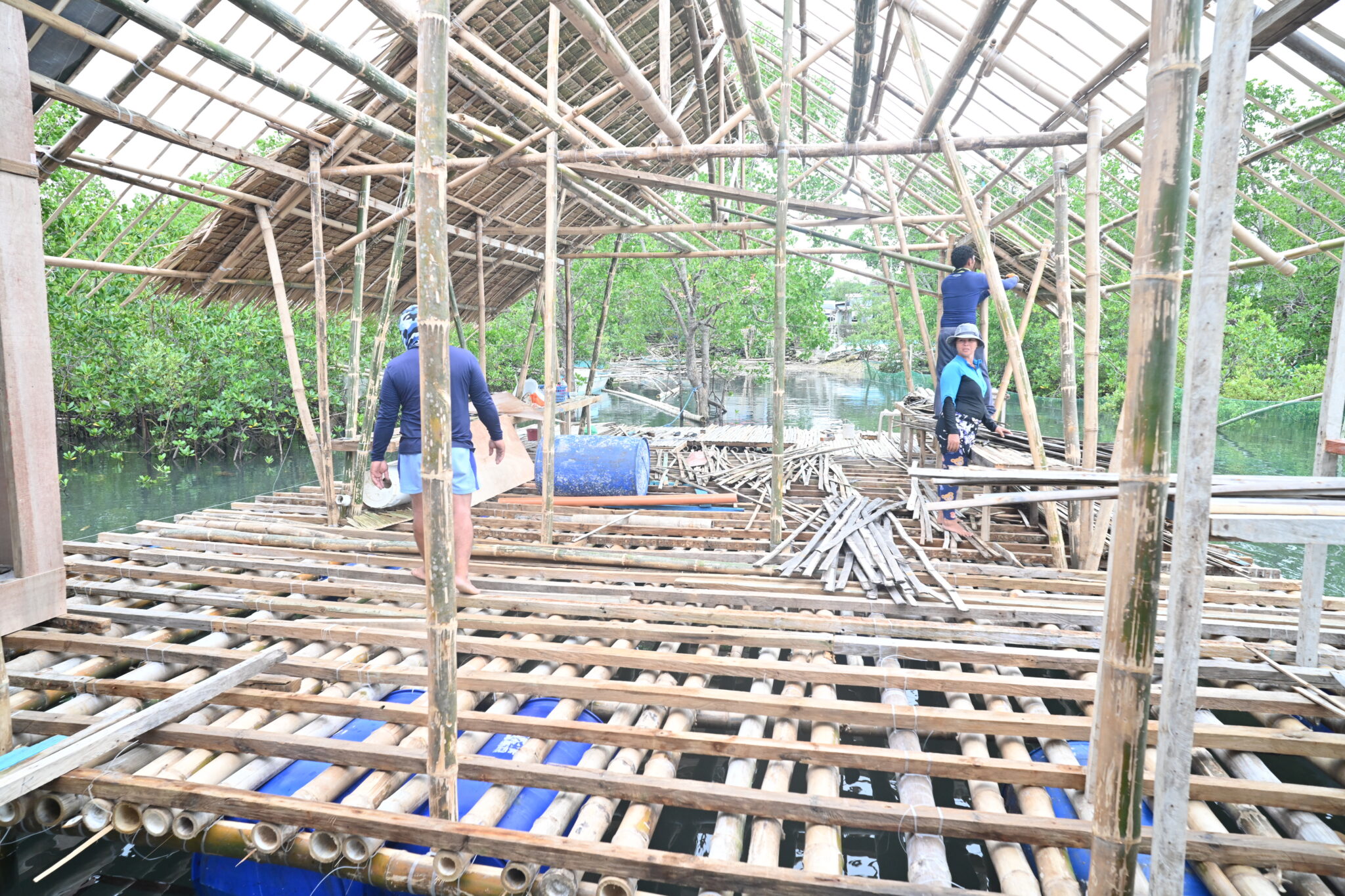 workers construct floor of partially rebuilt cabin