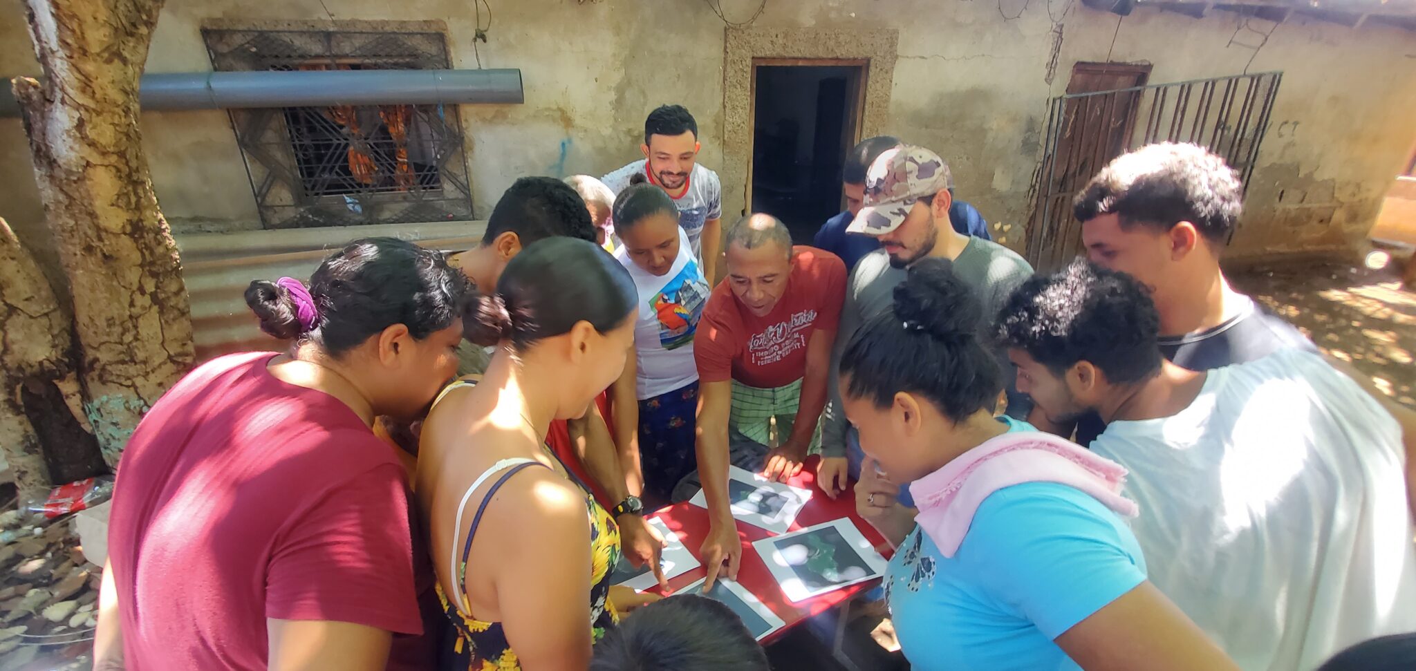 A group of students gathers around a teacher showing them a project