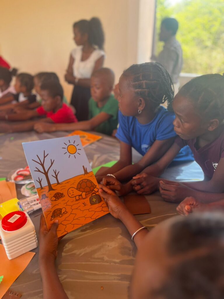 Kids sit at a table drawing pictures of turtles