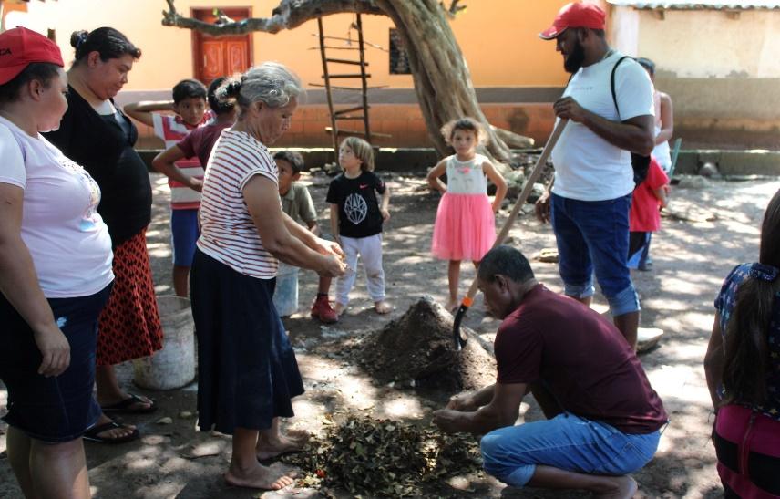 Two little kids watch as a few adults work