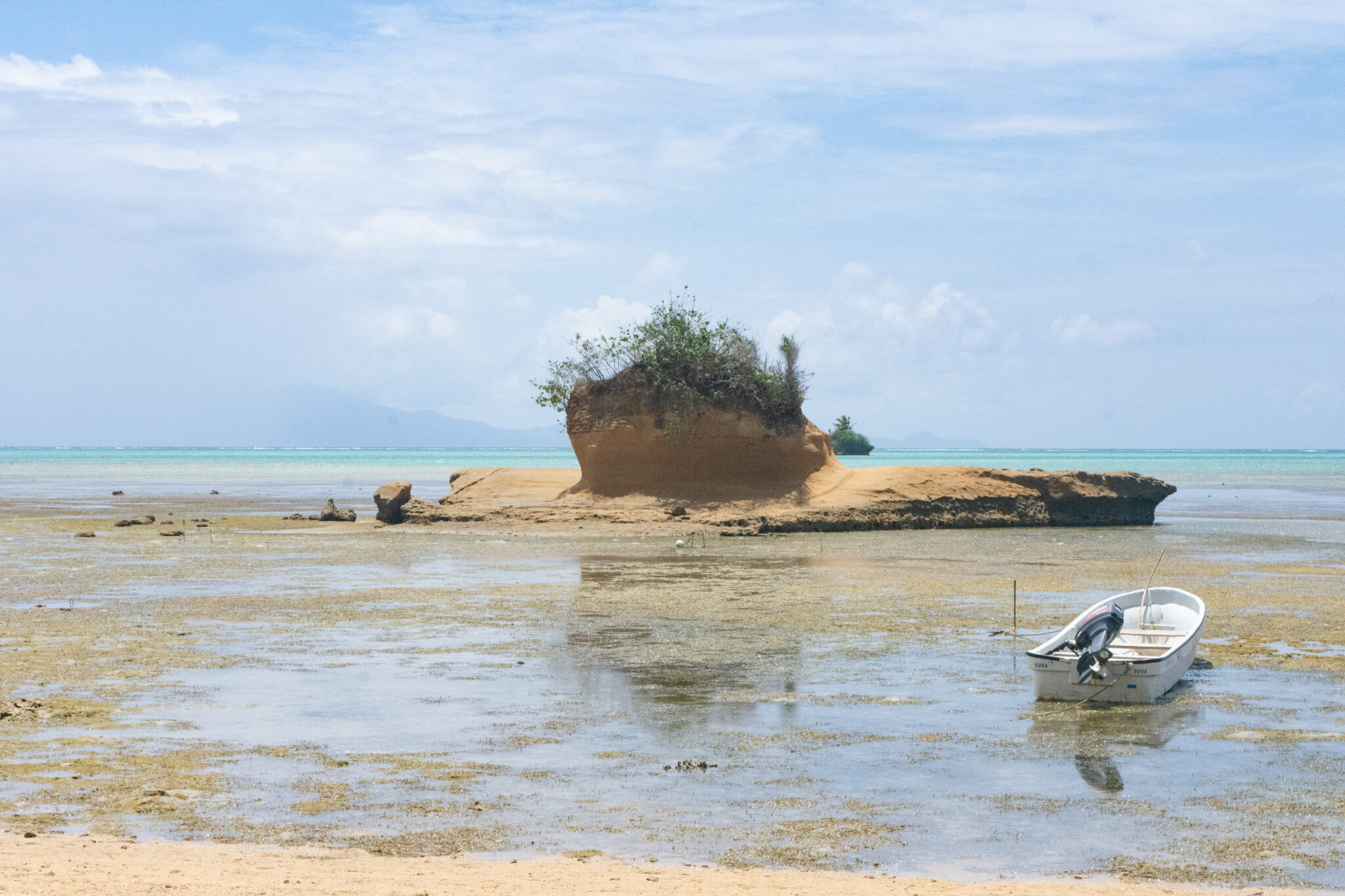 Looking out over sea with rock outcrop and boat
