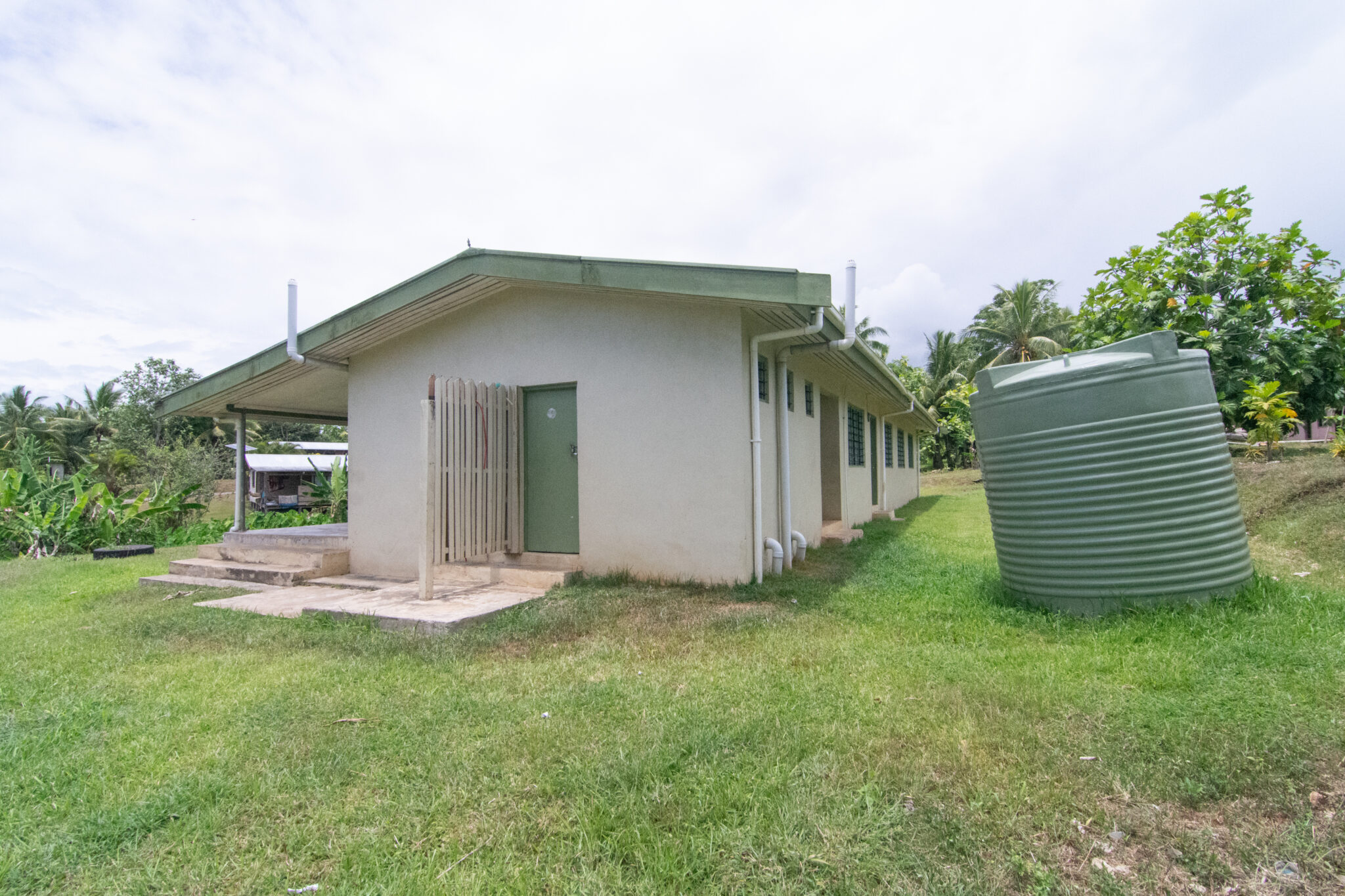 Rear view of concrete building with water tanks