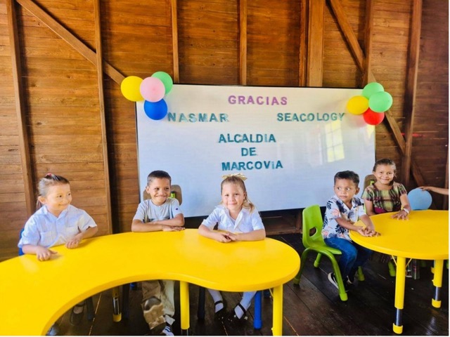 A group of kids sits at yellow tables