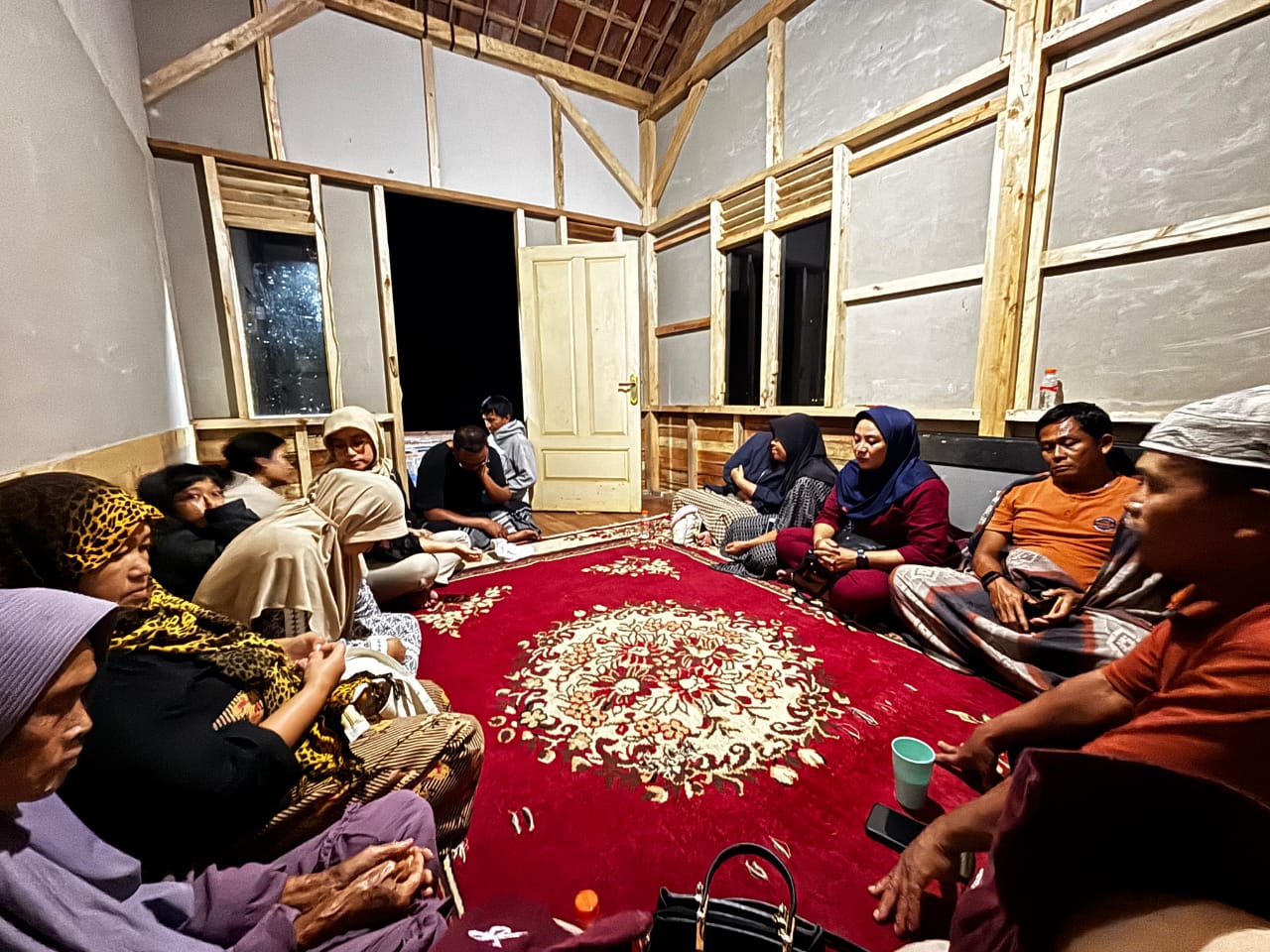 Group of people sit in circle on floor in new building