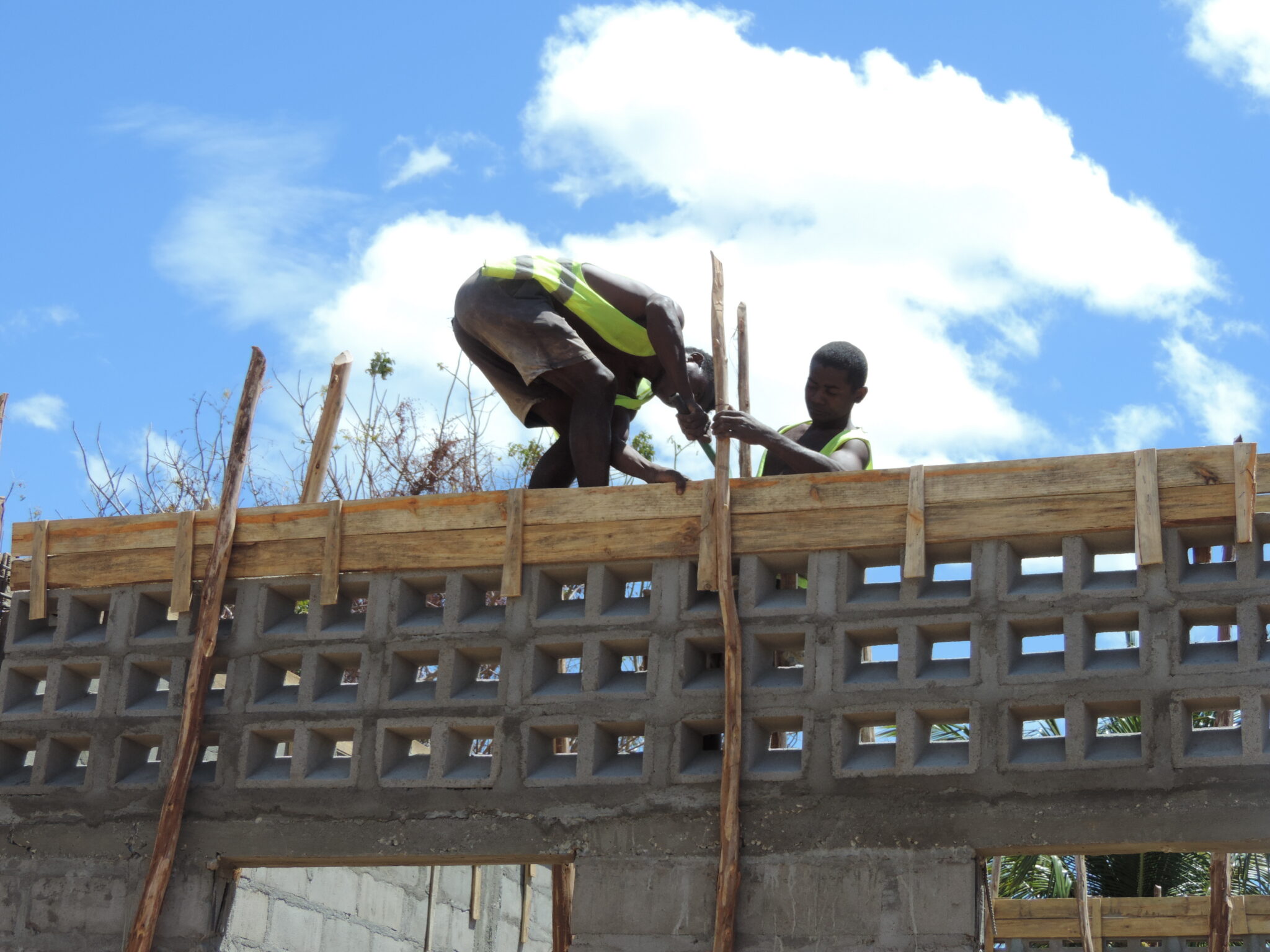 Two young men build concrete structure of building