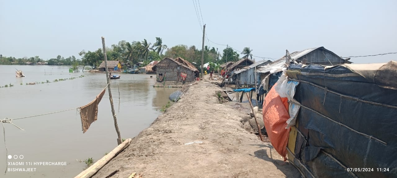 A dirt street with some building alongside