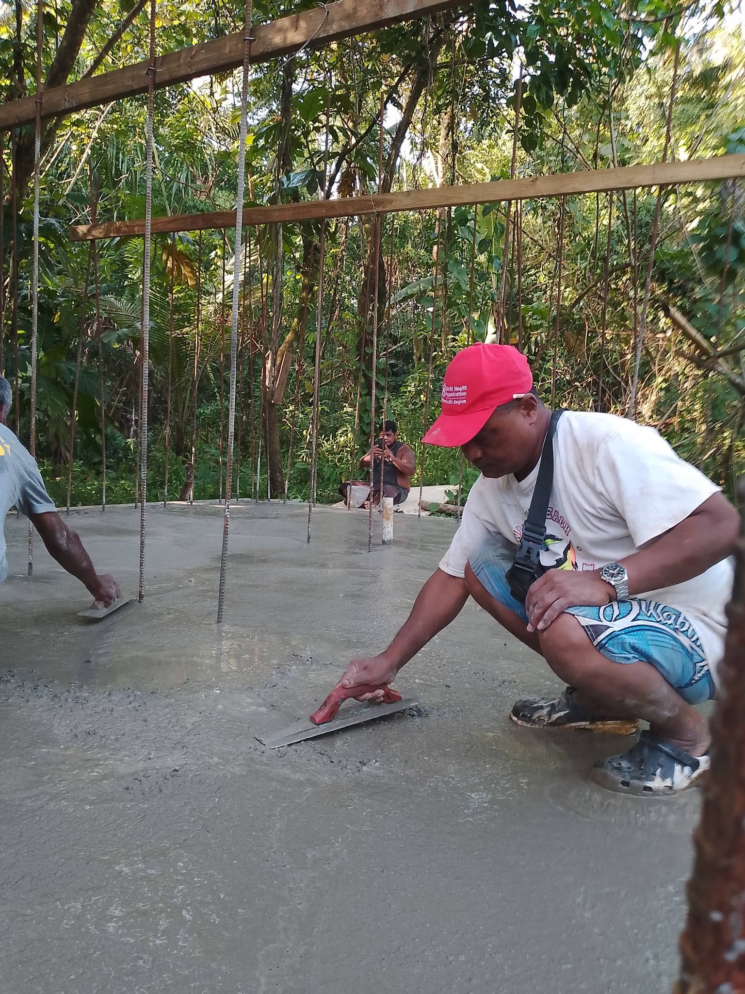 Worker smooths concrete for foundation