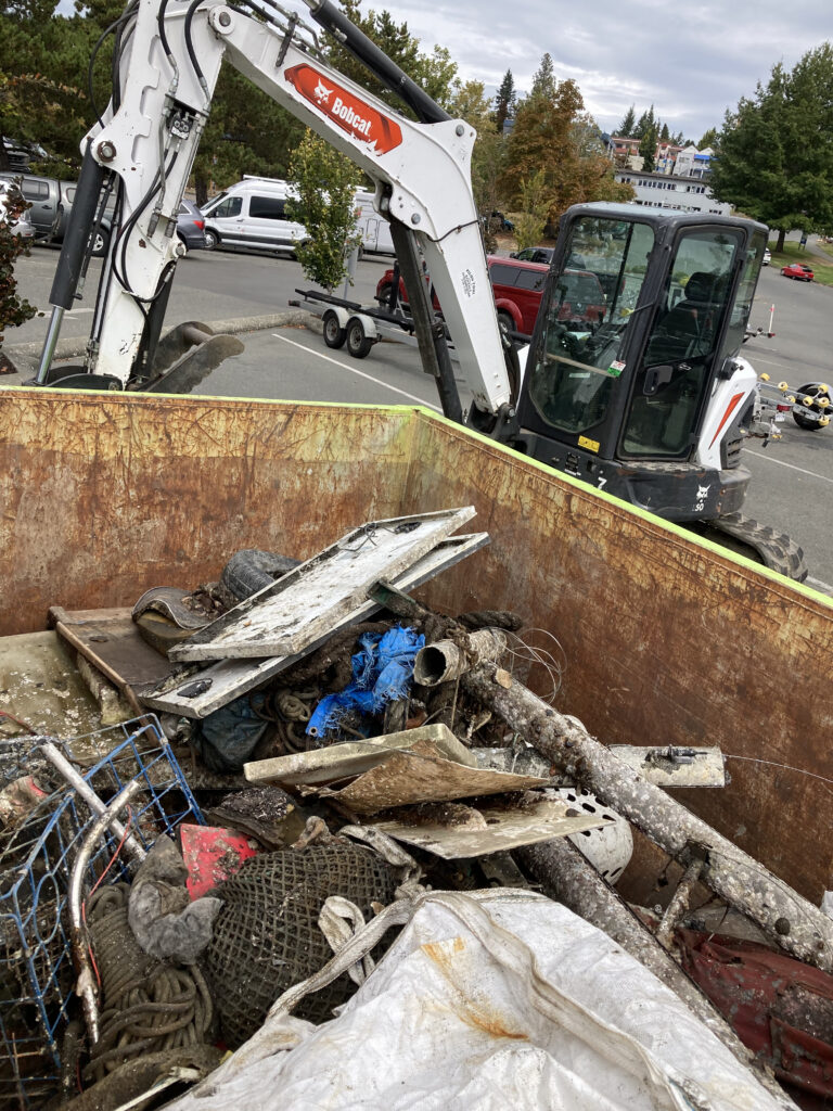 A dumpster filled with items removed from the estuary.
