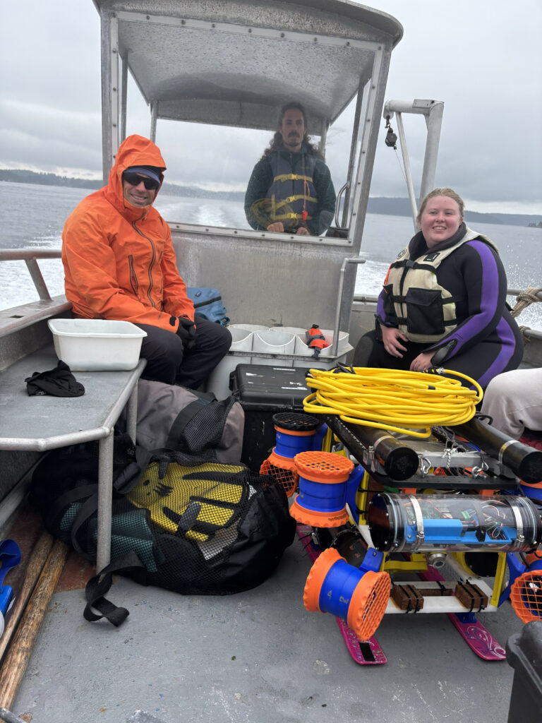 people on boat with seagrass planting robot