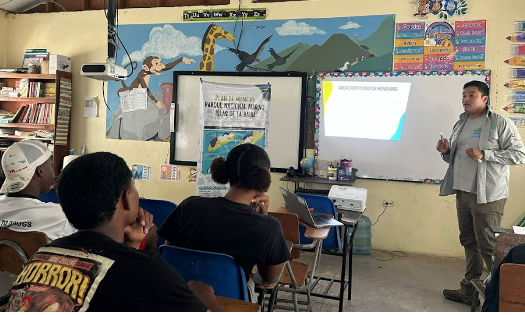 A group of students listen to a lesson in a classroom