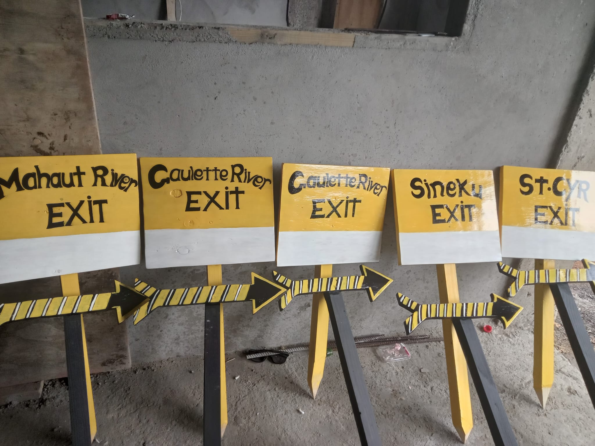 Yellow trails signs lean against wall