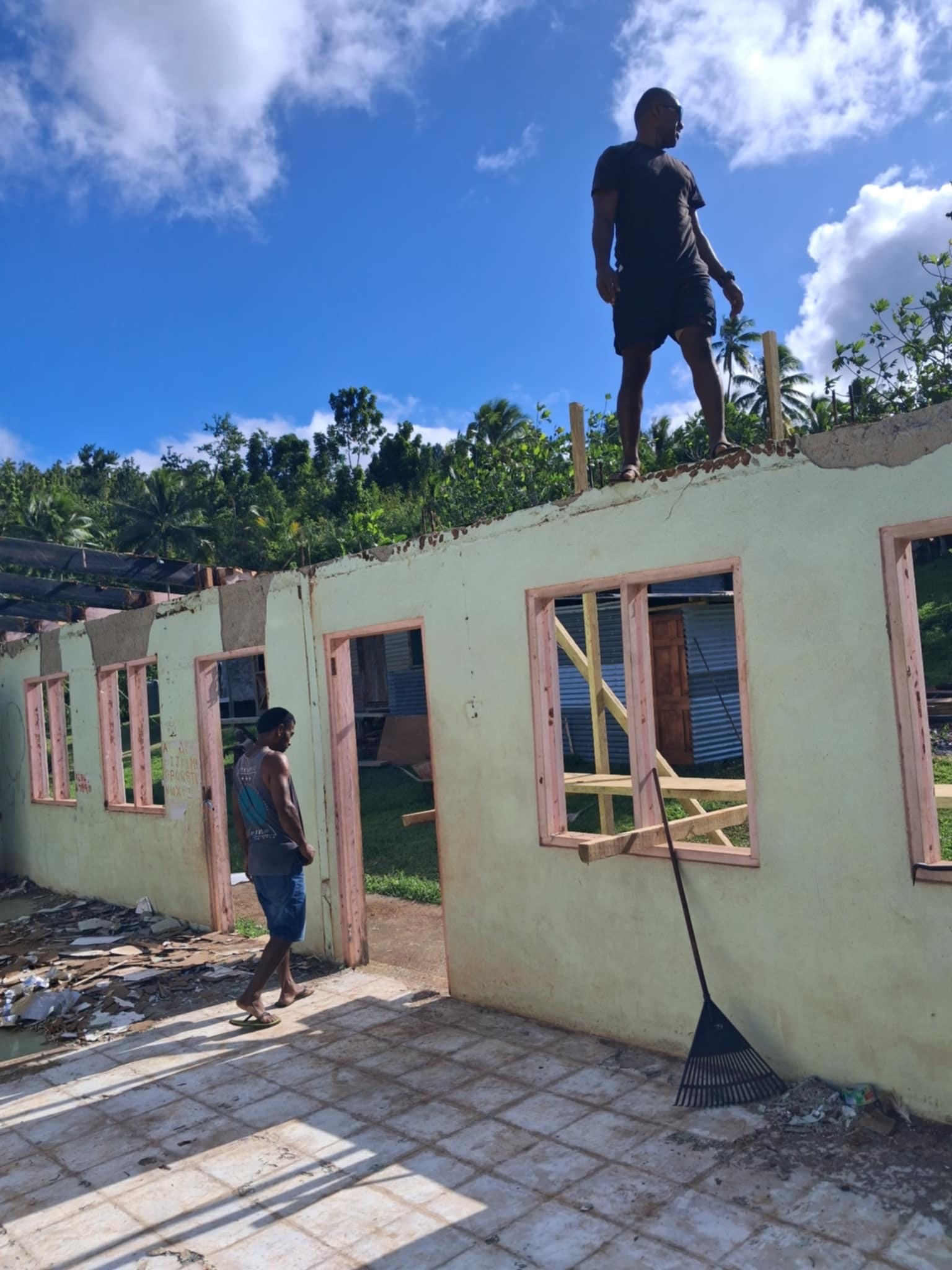 People standing on walls while constructing a building