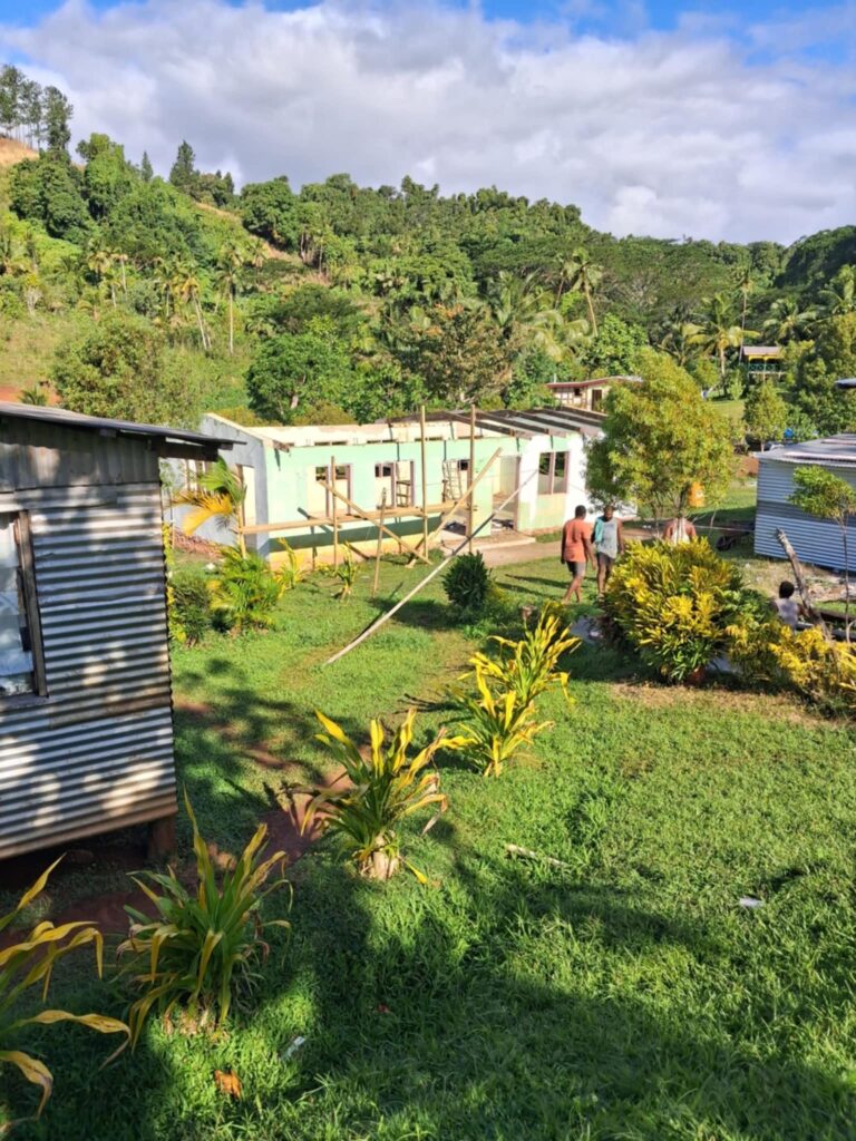 A building under construction against green tropical hills