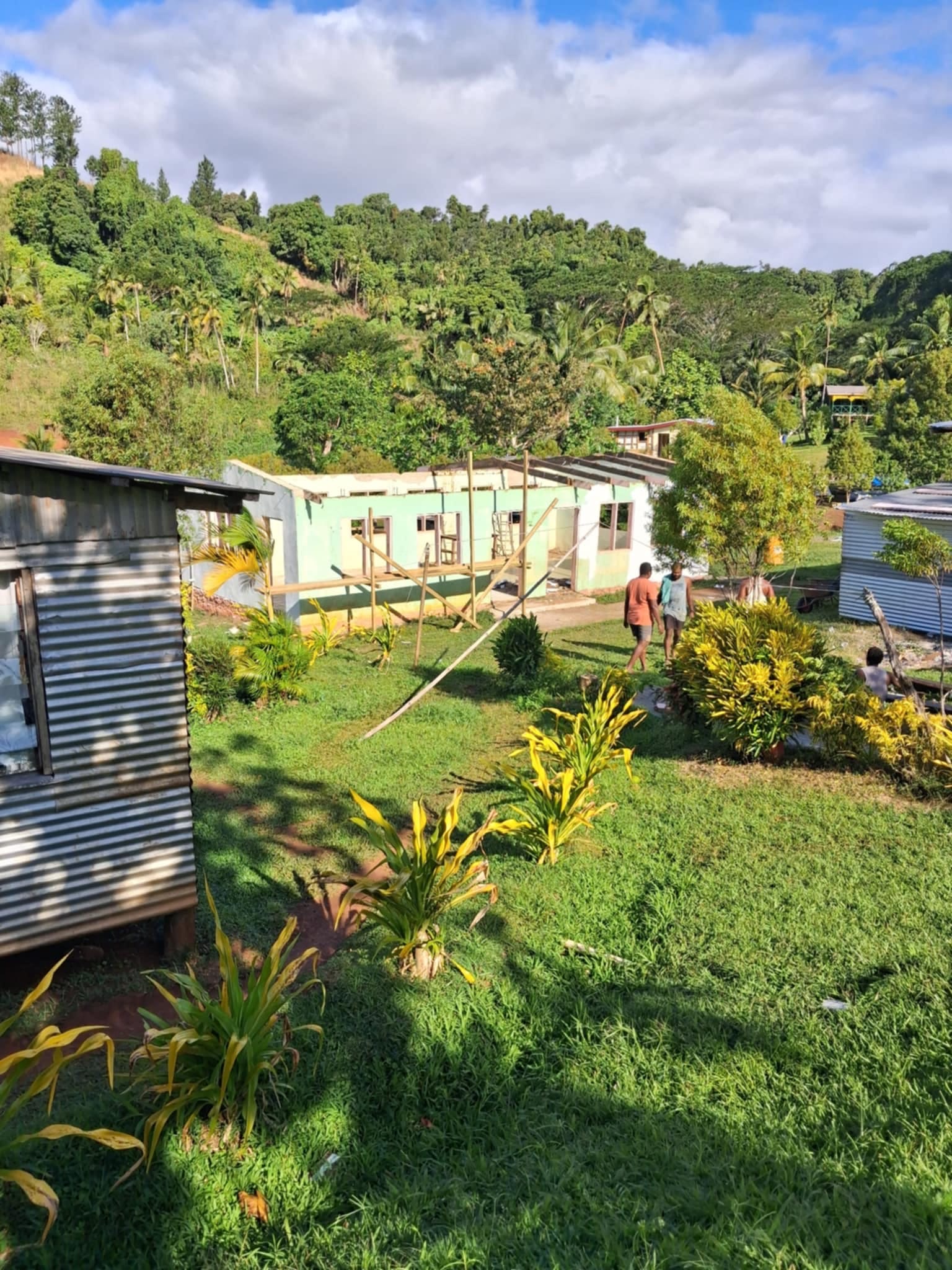 A building under construction against green tropical hills