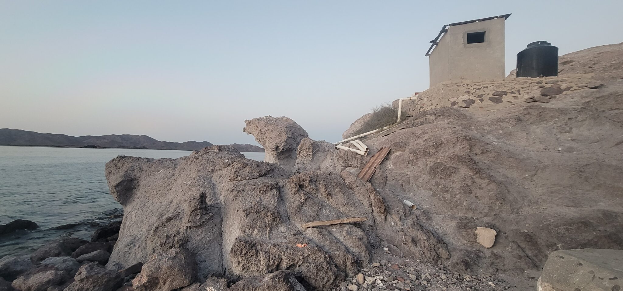A concrete hut on rocks over the water