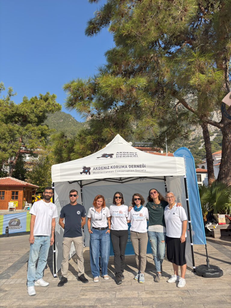 A group of people stand in front of a white easy-up