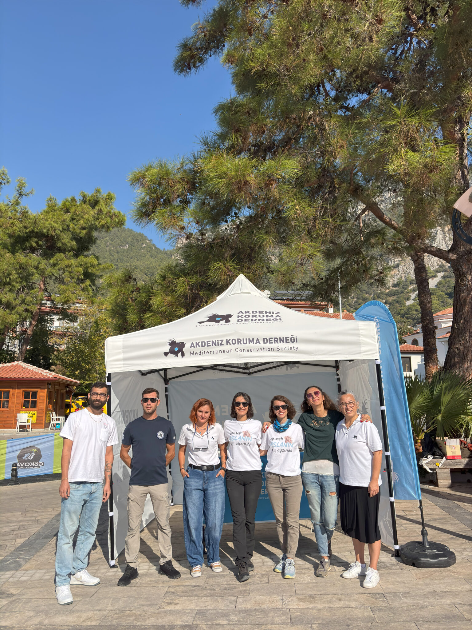 A group of people stand in front of a white easy-up