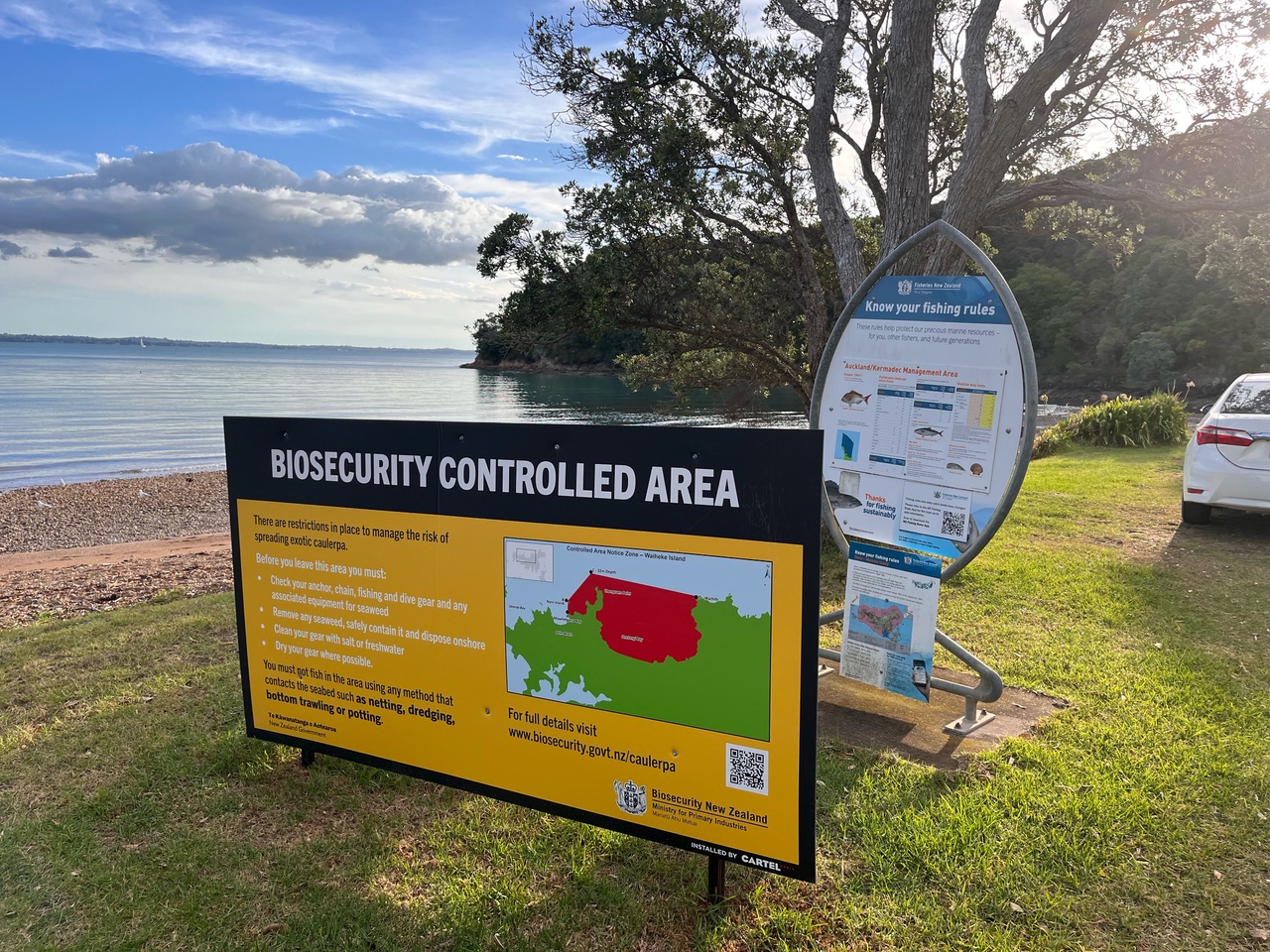 A large yellow sign that reads, "Biosecurity Controlled Area" next to a beach