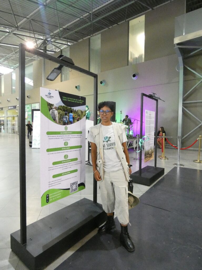 A person in a white uniform stands in front of an informational display