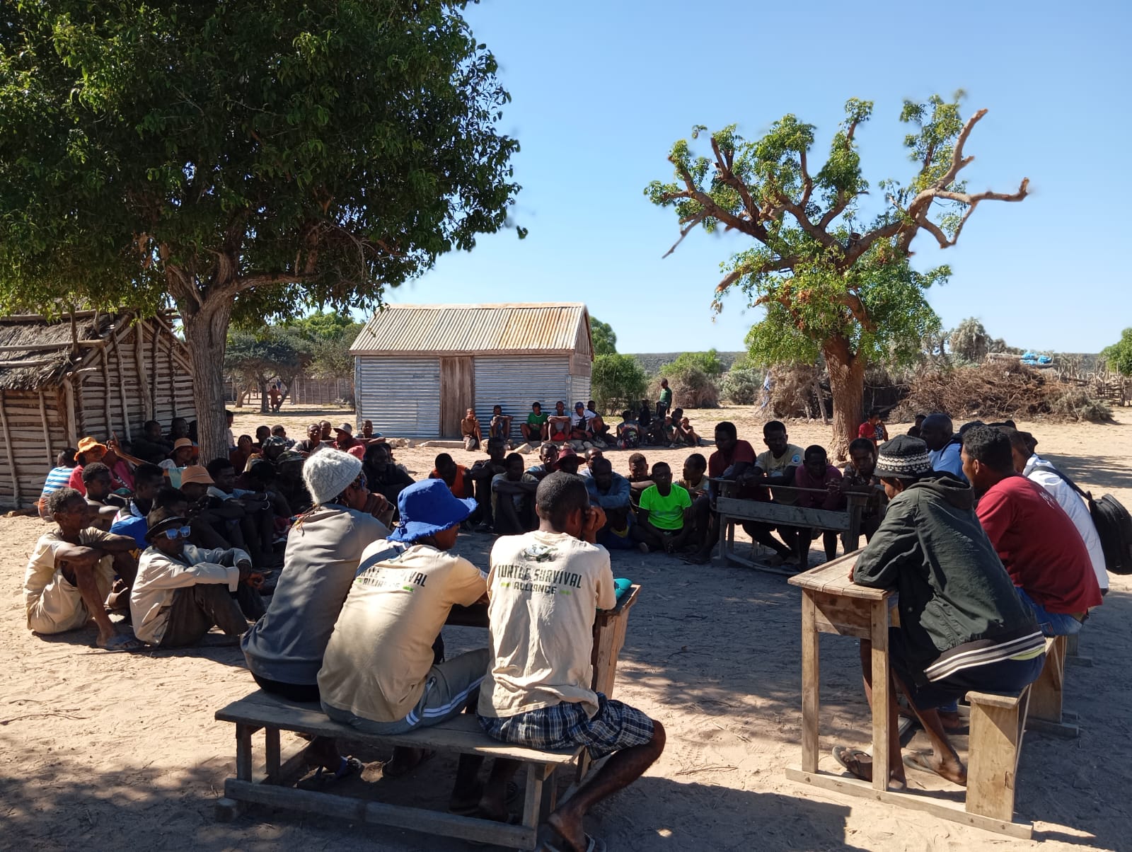 A group of people gather around benches and buildings