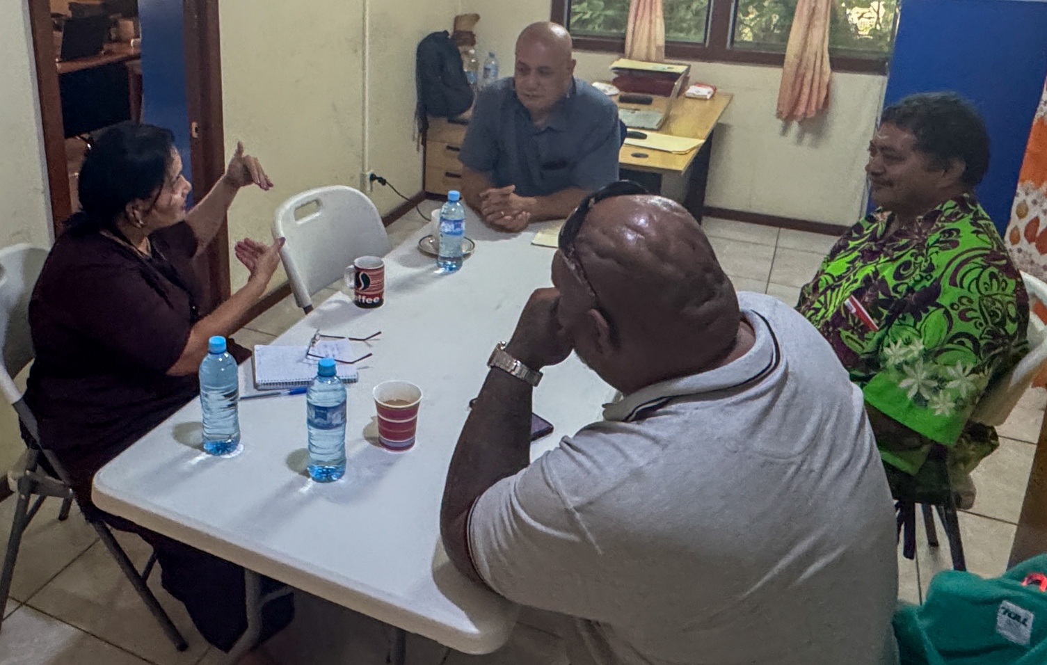 Four people have a discussion around a table
