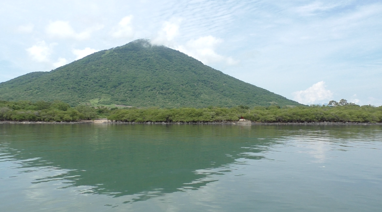 A green mountain overlooking the water