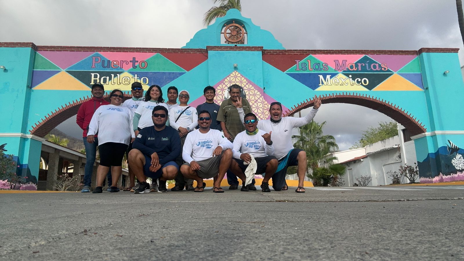 A group of people posing in front of a colorful building