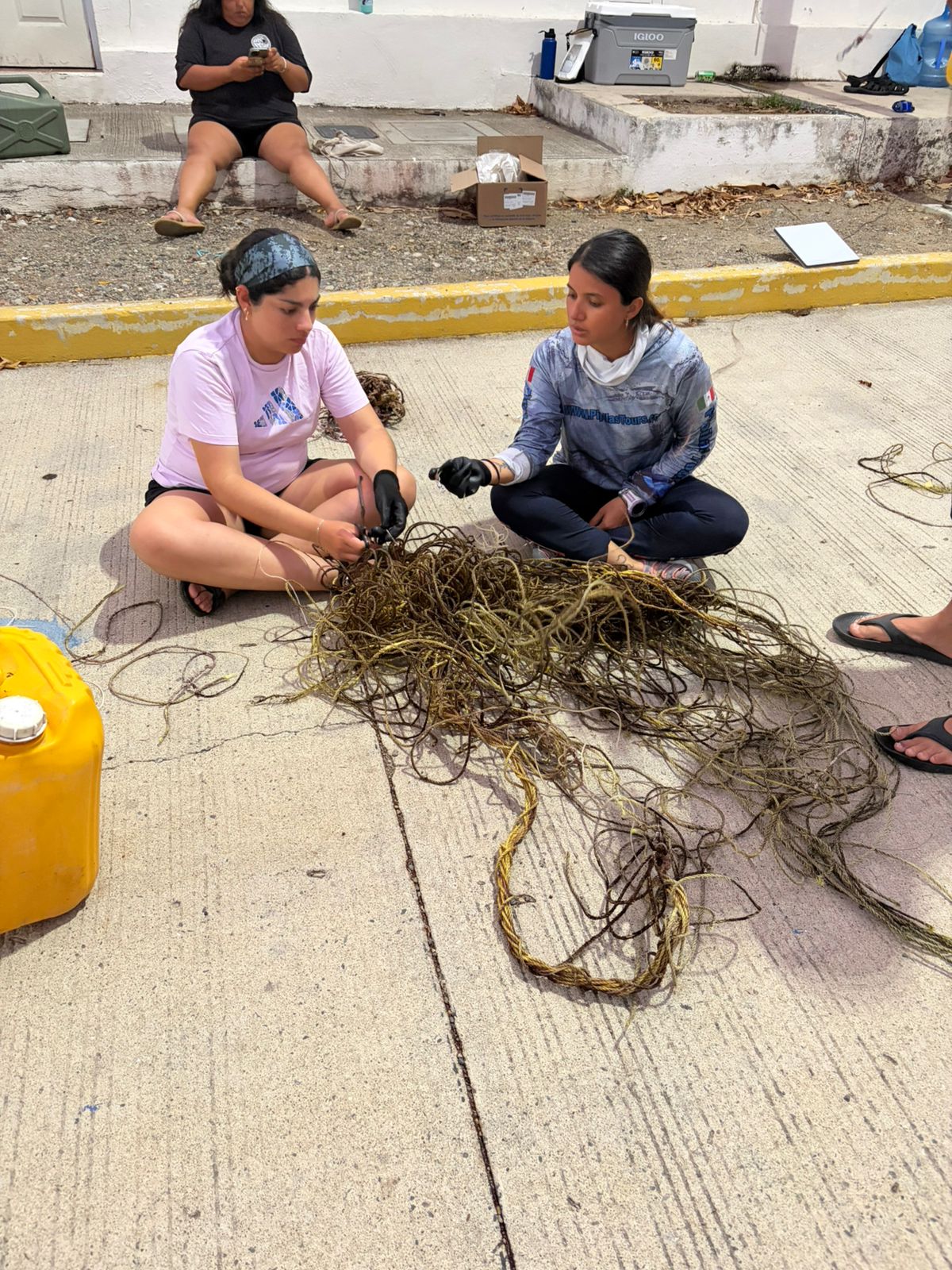 Two people sort through abandoned fishing gear