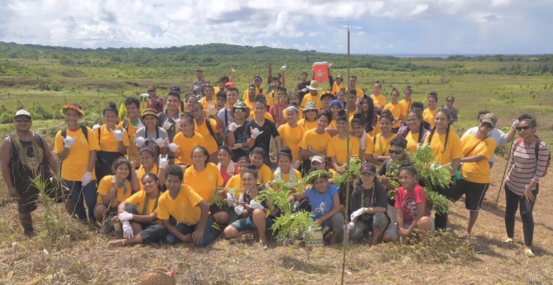 group of people with green field in background