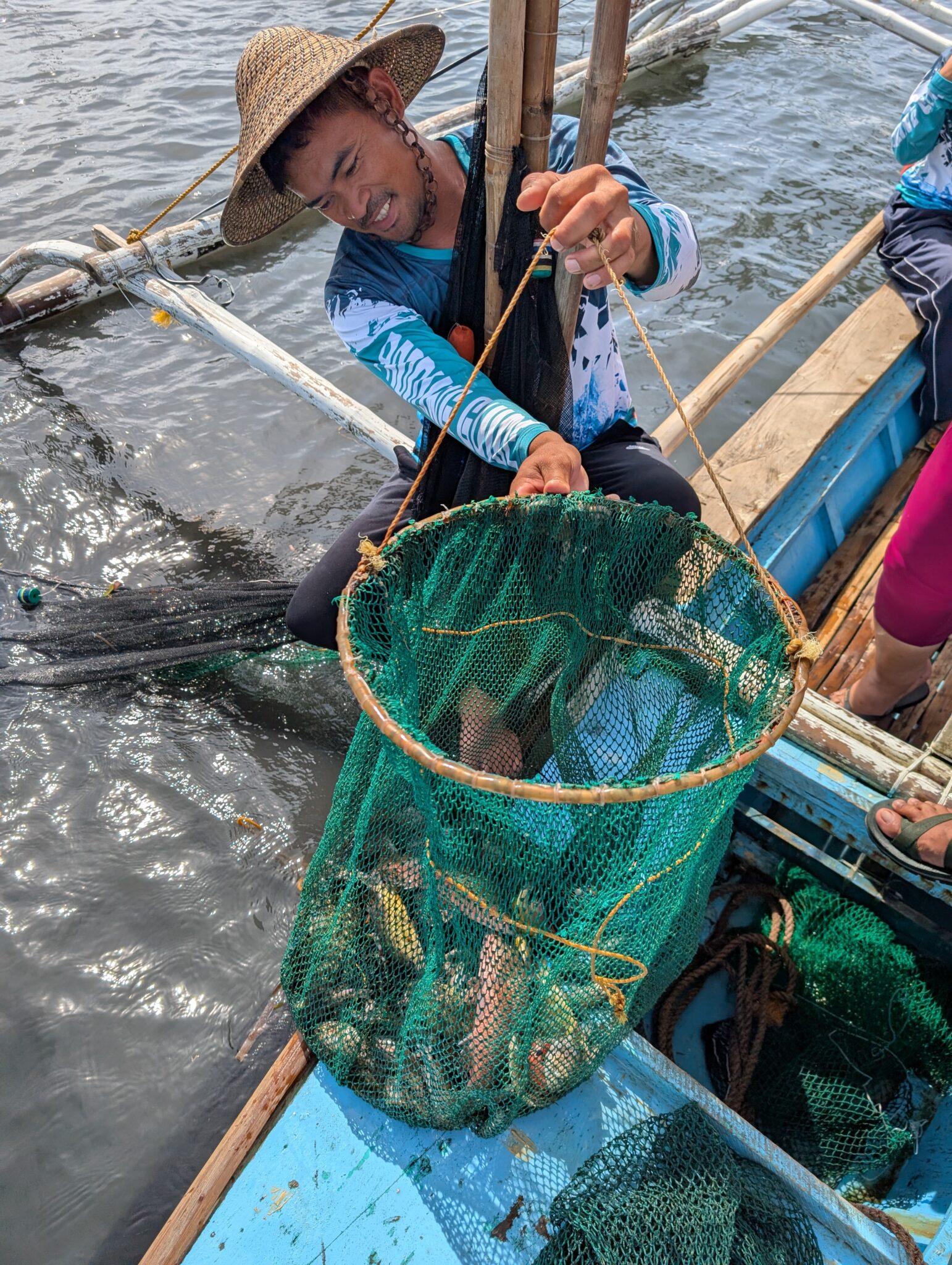 A person holding a net full of fish